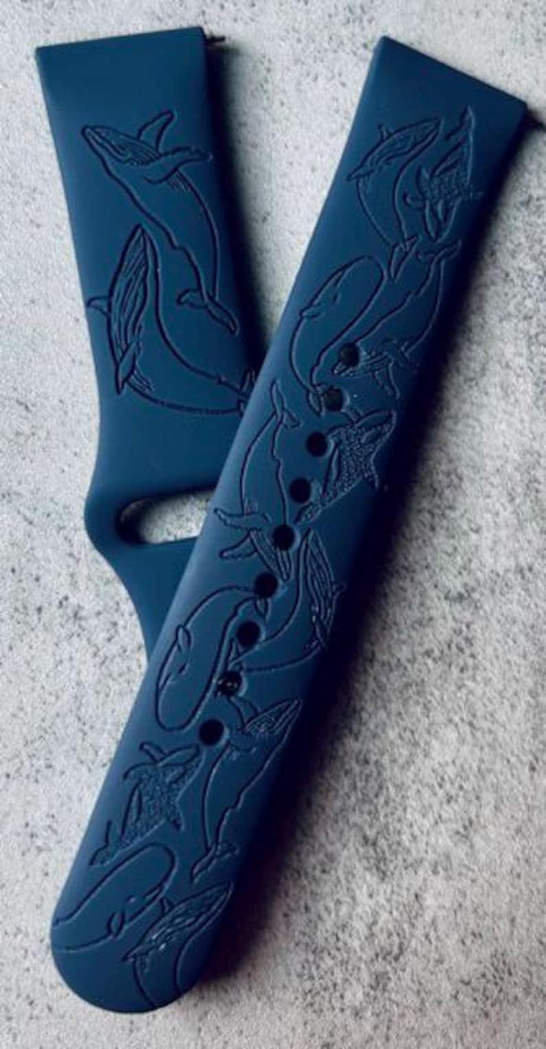 K&ouml;nnte beinhalten: Zwei dunkelblaue Silikon-Armb&auml;nder mit einem gepr&auml;gten Wal-Design. Die Armb&auml;nder sind aus einem weichen, flexiblen Material gefertigt und mit den meisten Smartwatches kompatibel.