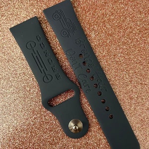 Puede incluir: Dos correas de reloj de silicona negra con dise&ntilde;os grabados. Una correa tiene un peque&ntilde;o dise&ntilde;o de cami&oacute;n y el texto "La aventura te espera, no esperes, explora." La otra correa tiene un dise&ntilde;o de l&iacute;nea con el texto "M&aacute;s all&aacute; de la E."