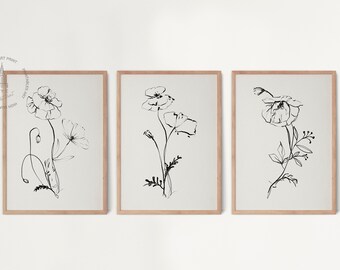Puede incluir: Conjunto de tres impresiones en blanco y negro de arte lineal con ilustraciones simples de flores de amapola. Cada impresión está enmarcada en un marco de madera claro.