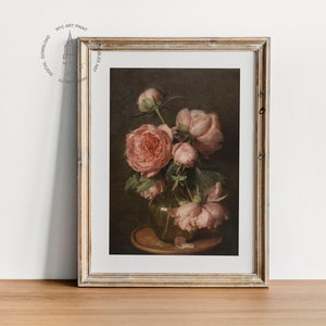 May include: A framed painting of a still life featuring a bouquet of pink peonies in a clear glass vase. The vase is sitting on a wooden table with a brown background.
