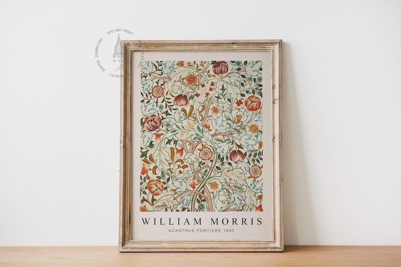 Op de afbeelding: Een ingelijste print van een vintage bloemenontwerp van William Morris. De print heeft een herhalend patroon van gestileerde bloemen en bladeren in tinten rood, oranje, geel, groen en blauw. De tekst "William Morris Acanthus Portiere 1880" is onder het ontwerp gedrukt.