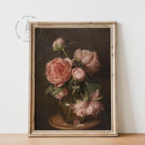 May include: A framed painting of a still life featuring a bouquet of pink peonies in a glass vase. The flowers are arranged in a vase on a wooden table. The background is a dark brown color.