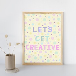 May include: A framed print with a yellow background and colourful polka dots. The text "Let's Get Creative" is written in a playful font.