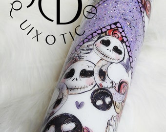 May include: A purple glitter tumbler with a white design featuring multiple images of Jack Skellington from the Nightmare Before Christmas. The tumbler has a black and white design with hearts and swirls.