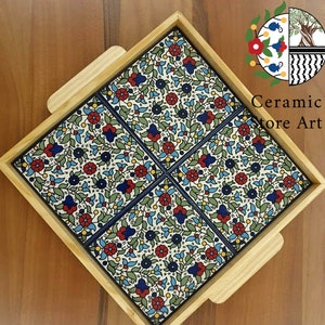 Puede incluir: Una bandeja de madera con cuatro azulejos cuadrados de cer&aacute;mica. Los azulejos est&aacute;n decorados con un patr&oacute;n floral en tonos azules, rojos y verdes. La bandeja es perfecta para servir aperitivos o bebidas.