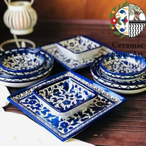 Puede incluir: Conjunto de cuencos y platos de cerámica azul y blanca con intrincados diseños florales. Los cuencos están anidados uno dentro del otro y los platos son cuadrados. El conjunto es perfecto para servir aperitivos, postres o refrigerios.