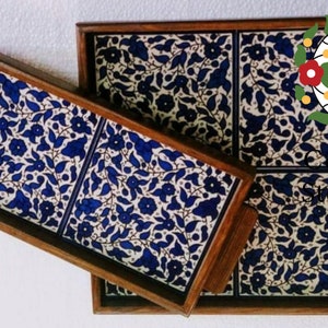 Puede incluir: Dos bandejas de servir de madera con inserciones de azulejos florales azules y blancos. La bandeja m&aacute;s grande tiene cuatro azulejos y la bandeja m&aacute;s peque&ntilde;a tiene dos azulejos.