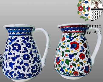 May include: Two ceramic pitchers with floral designs. The pitcher on the left has a blue and white floral pattern. The pitcher on the right has a multi-colored floral pattern with red, yellow, blue, and green accents.