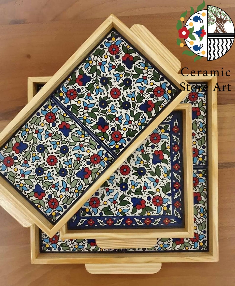 Puede incluir: Tres bandejas de servir de madera con intrincados dise&ntilde;os florales en azul, rojo, verde y amarillo. Las bandejas est&aacute;n anidadas, con la bandeja m&aacute;s grande en la parte inferior y la bandeja m&aacute;s peque&ntilde;a en la parte superior.