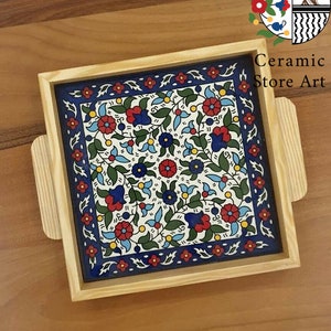 Puede incluir: Una bandeja de madera con una baldosa de cer&aacute;mica azul y blanca insertada. La baldosa presenta un patr&oacute;n floral con acentos rojos, azules, verdes y amarillos. La bandeja tiene dos asas a los lados.