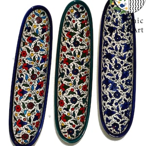 Könnte beinhalten: Drei Keramik-Servierplatten mit einem floralen Muster in Blautönen, Grün, Rot und Gelb. Die Platten sind oval geformt und haben einen weißen Hintergrund.