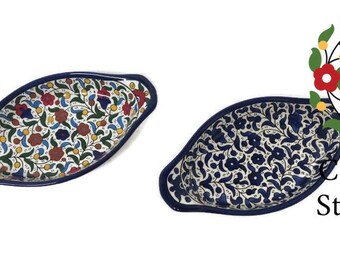 Könnte beinhalten: Zwei keramikförmige Servierschalen mit dunkelblauem Rand. Eine Schale hat ein farbenfrohes Blumenmuster mit roten, blauen und gelben Akzenten. Die andere Schale hat ein dunkelblaues Blumenmuster. Der Text "Ceramic Store Art" ist sichtbar.