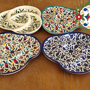Könnte beinhalten: Vier Keramik-Servierplatten mit verschiedenen Blumenmustern. Jede Platte hat drei Abschnitte zum Servieren von Dips oder Snacks. Die Platten sind weiß mit blauen, roten und grünen Blumenmustern.