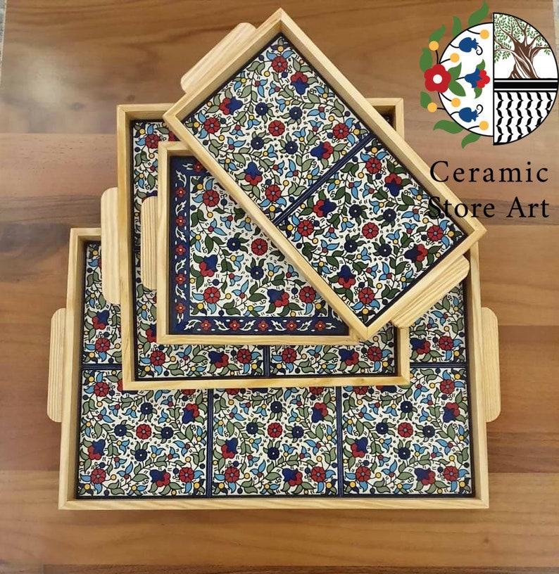 Puede incluir: Conjunto de cuatro bandejas de madera con azulejos de cer&aacute;mica con motivos florales. Los azulejos presentan un dise&ntilde;o floral azul, blanco, verde y rojo. Las bandejas est&aacute;n apiladas unas sobre otras.