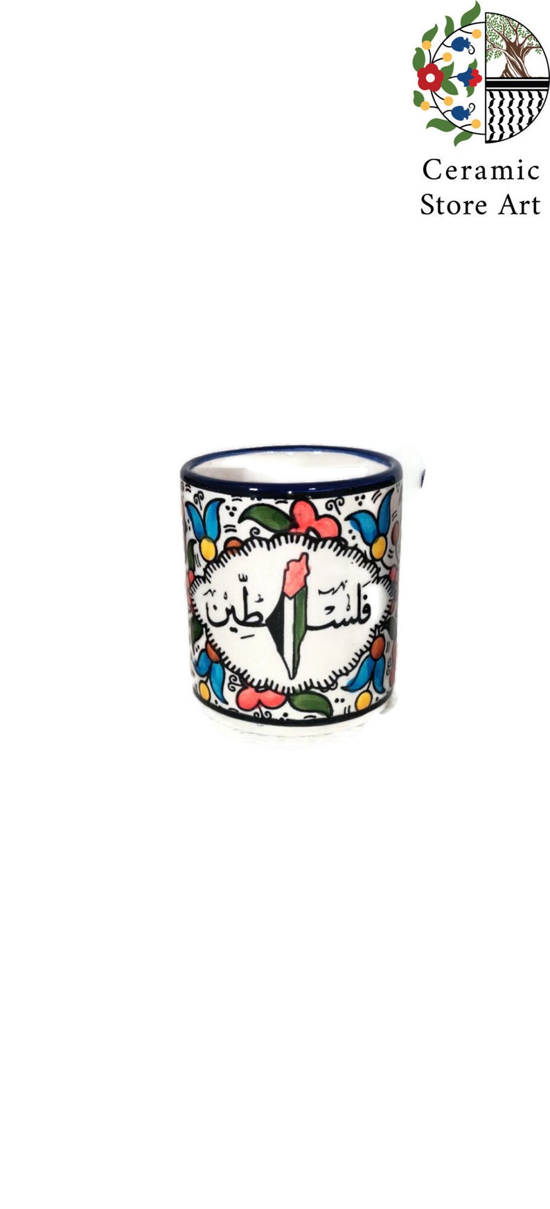 May include: A white ceramic mug with a blue rim and a colorful floral design. The mug features a green, white, and black Palestinian flag with Arabic text that reads "Palestine".