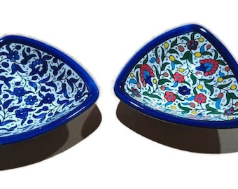 May include: Two triangular ceramic bowls with blue rims and intricate floral patterns in shades of blue, red, yellow, and green.