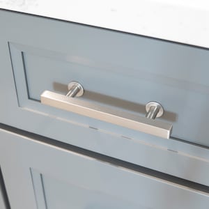 May include: A close-up of a gray cabinet drawer with a brushed nickel pull handle.