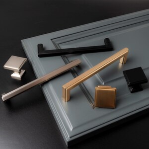 May include: Assortment of cabinet hardware in various finishes, including brushed nickel, gold, and black. The hardware includes pulls and knobs in different sizes and styles.