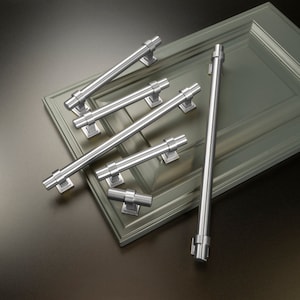 May include: A set of six silver cabinet pulls and knobs. The pulls are all different lengths and have a simple, modern design.