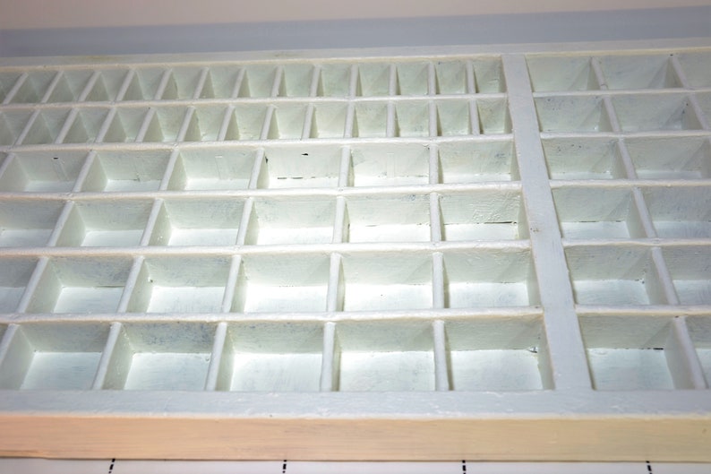 May include: White wooden storage box with multiple compartments. The box is empty and has a light wood finish.