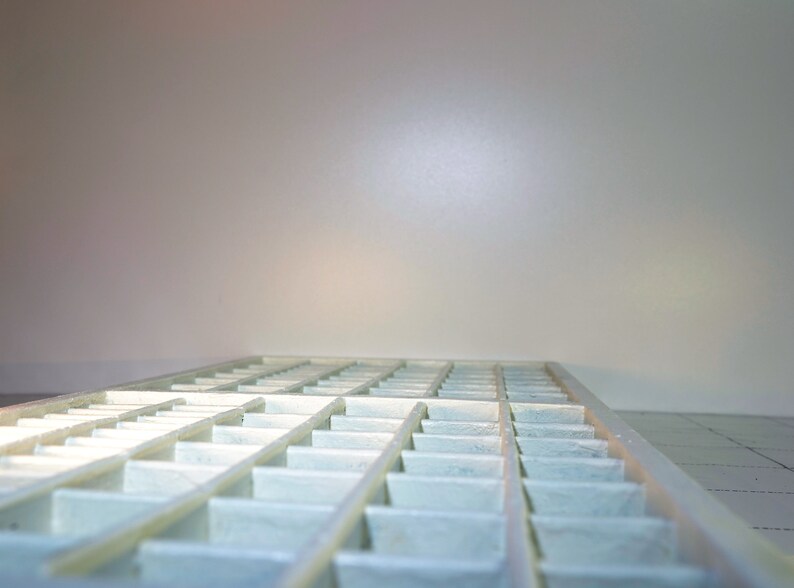 May include: A white plastic tray with multiple compartments, arranged in a grid pattern. The tray is empty and appears to be new.