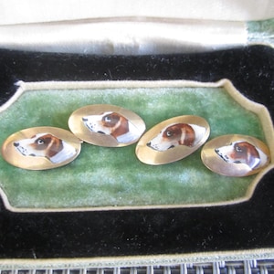 May include: Set of four gold cufflinks with painted images of hound dogs. The cufflinks are in a velvet lined box.
