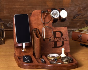 May include: A wooden organizer with compartments for a phone, wallet, watch, glasses, and other small items. The organizer is personalized with the name "BRIANNA" in a decorative font.