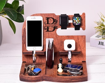 May include: A wooden phone and watch stand with a personalized inscription that reads "Benjamin". The stand has slots for a phone, watch, keys, and a wallet. It also has a small shelf for a charging pad.