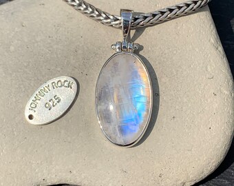 May include: A silver chain necklace with a silver pendant featuring a large oval moonstone. The pendant has a silver bail and a Johnny Rock 925 tag is visible in the image.
