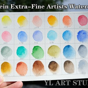 K&ouml;nnte beinhalten: Eine Aquarell-Farbkarte mit 18 verschiedenen Farben, darunter Gelb, Orange, Rot, Rosa, Blau, Gr&uuml;n, Braun und Grau. Die Karte ist mit Zahlen beschriftet, und der Text "Holbein Extra-Fine Artists Watercolor" befindet sich oben. Der Text "YL ART STUDIO" befindet sich unten.
