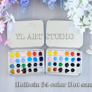 K&ouml;nnte beinhalten: Eine silberne Metall-Farbpalette mit 24 Aquarell-Farbtupfern in verschiedenen Farben. Die Palette ist mit "YL ART STUDIO" und "Holbein 24 color Dot sample" beschriftet.