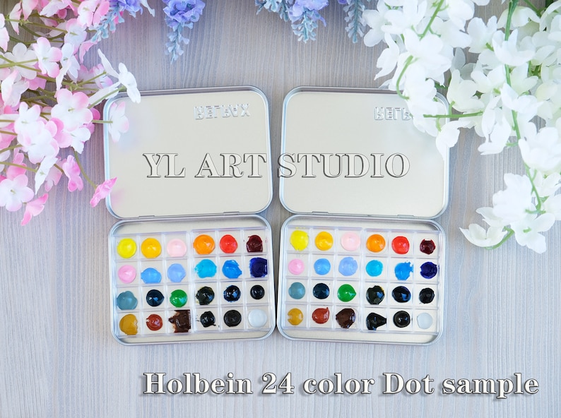 K&ouml;nnte beinhalten: Eine silberne Metall-Farbpalette mit 24 Aquarell-Farbtupfern in verschiedenen Farben. Die Palette ist mit "YL ART STUDIO" und "Holbein 24 color Dot sample" beschriftet.
