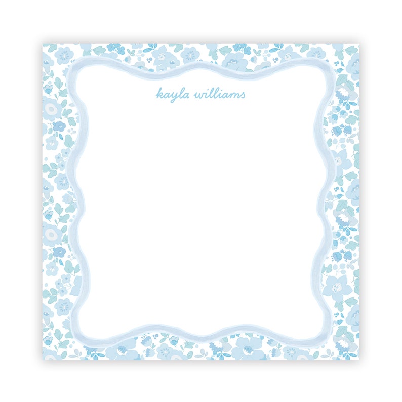 May include: A white notepad with a blue floral border and the name "kayla williams" written in blue cursive.