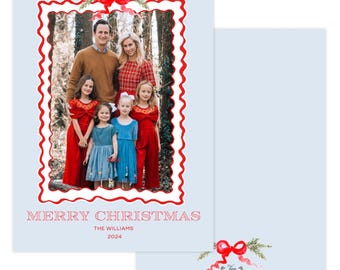 May include: A light blue Christmas card with a family photo inside a red scalloped frame. The card reads "MERRY CHRISTMAS" with the family name and year. A red bow and greenery adorn the top. The back of the card has a matching bow and greenery design.