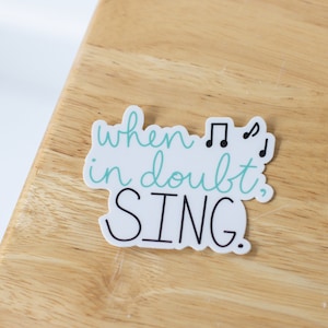 May include: White sticker with black text and musical notes that reads "when in doubt, SING."
