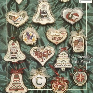 May include: A collection of 13 cross-stitch Christmas ornament patterns featuring various designs, including a bell, a heart, a tree, and a house. The patterns are printed on a white background with a green and white ribbon.