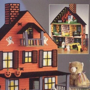 May include: A Halloween-themed dollhouse with an orange exterior, black trim, and white ghost decorations. The dollhouse has a porch with a railing and a small front yard with a black cat and a teddy bear. The dollhouse is made of plastic canvas and is a craft project.