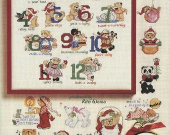 May include: A cross-stitch pattern featuring a teddy bear holding a number for each day of the month, with a Christmas theme. The pattern includes images of a Christmas tree, a goose, a swan, a snowman, a panda, and Santa Claus.