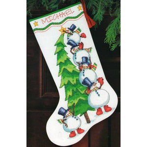May include: A white Christmas stocking with the name "MICHAEL" embroidered on the top.  The stocking features a green Christmas tree with four snowmen climbing up the tree to place a star on top.