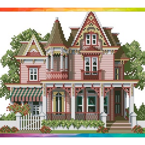 May include: A pink Victorian-style house with white trim and a wraparound porch. The house has a green roof and white picket fence. There are trees and bushes surrounding the house.