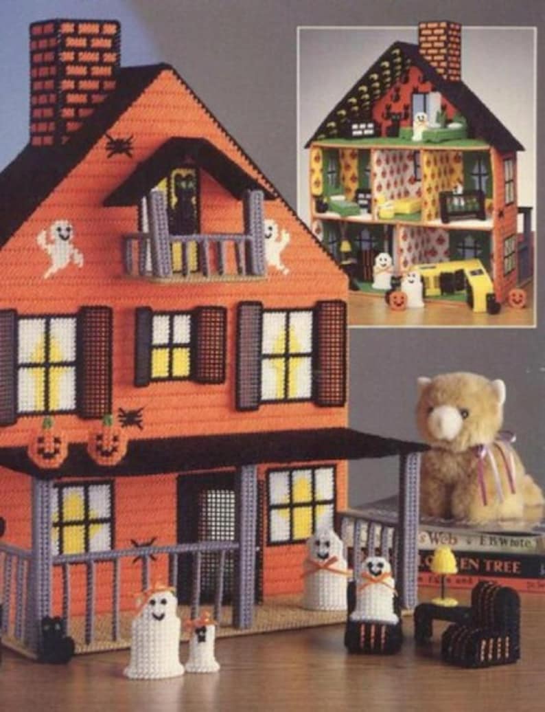 May include: A Halloween-themed dollhouse with an orange exterior, black trim, and white ghost decorations. The dollhouse has a porch with a railing and a small front yard with a black cat and a teddy bear. The dollhouse is made of plastic canvas and is a craft project.