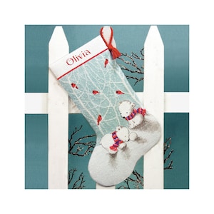 May include: A Christmas stocking with a winter scene featuring two polar bears wearing red and purple scarves. The stocking has a light blue background with red birds and the name "Olivia" at the top. A red tassel hangs from the top.