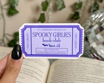 May include: A purple and blue admission ticket for a "Spooky Girllies Book Club" meeting on October 31st at Halloween Town Bookstore.