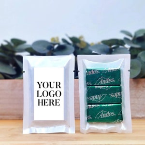 May include: Two clear plastic pouches, one with a white label that says "YOUR LOGO HERE" and the other with three individually wrapped Andes mints.