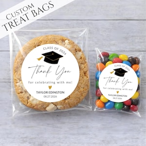 May include: Two clear treat bags, one with a large cookie and the other with colorful candies. Both bags have a white circular sticker with a graduation cap, the text "Thank You", and the date 08.27.2026.