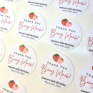 Może przedstawiać: Okrągłe białe naklejki z r&oacute;żowymi i czerwonymi truskawkami i tekstem "Thank You Berry Much!" z imieniem Joanne's 65th Birthday i datą March 29th, 2025.