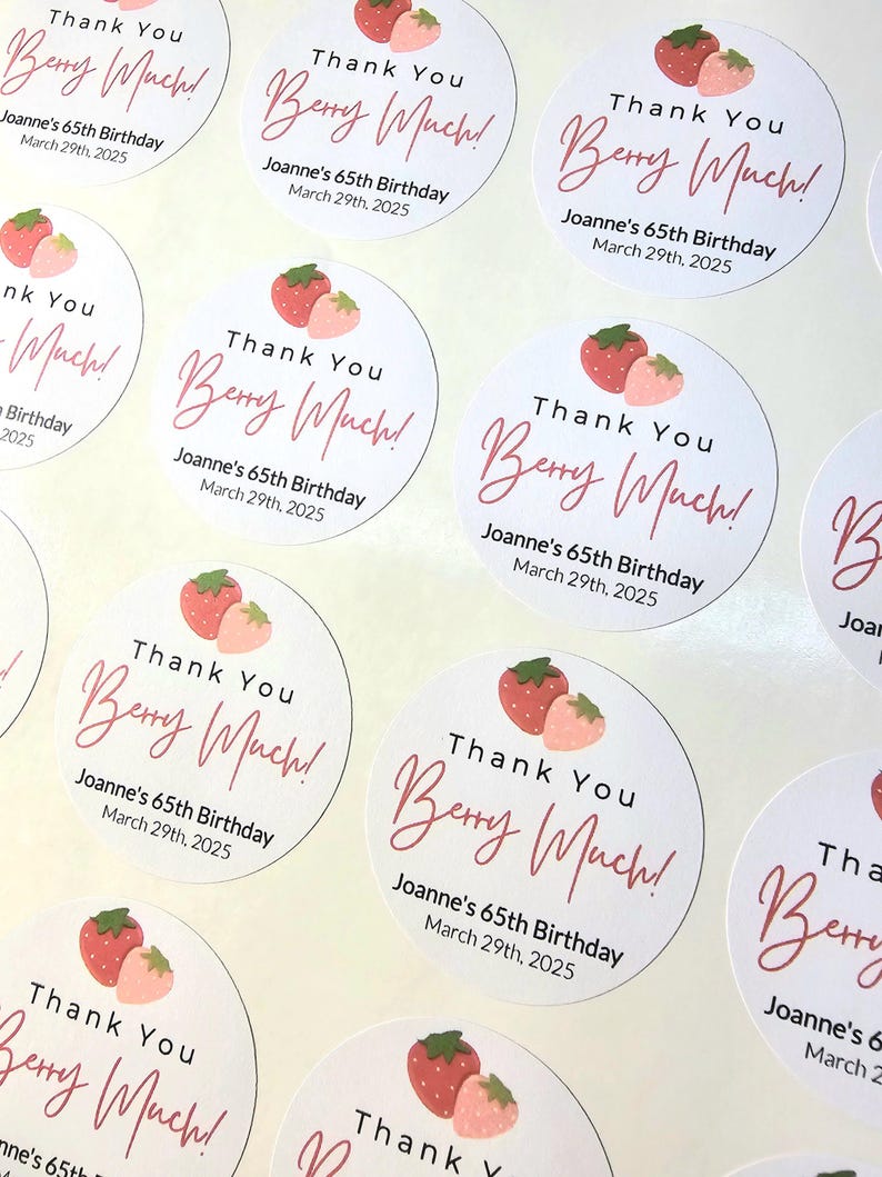 Może przedstawiać: Okrągłe białe naklejki z r&oacute;żowymi i czerwonymi truskawkami i tekstem "Thank You Berry Much!" z imieniem Joanne's 65th Birthday i datą March 29th, 2025.