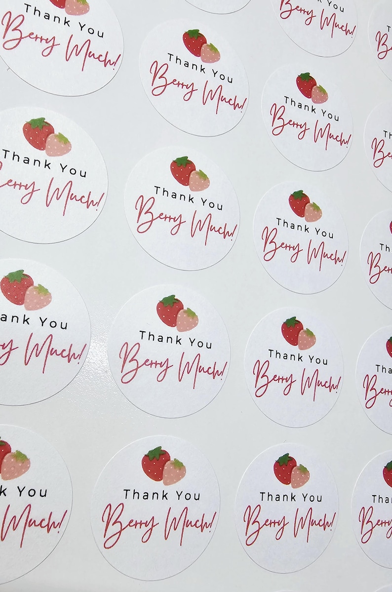 Może przedstawiać: Arkusz okrągłych naklejek z grafiką truskawki i tekstem "Thank You Berry Much!" nadrukowanym na r&oacute;żowo na każdej naklejce.