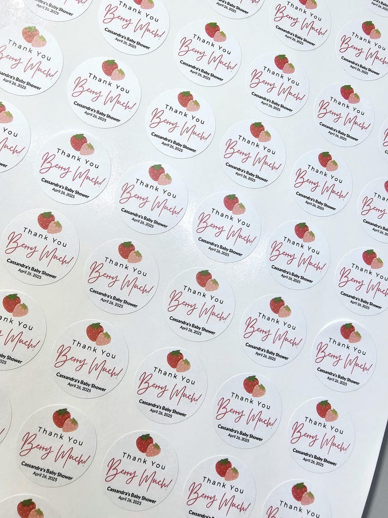 Może przedstawiać: Arkusz okrągłych, białych naklejek z grafiką r&oacute;żowej i czerwonej truskawki oraz tekstem "Thank You Berry Much!" Cassandra's Baby Shower April 26, 2025.