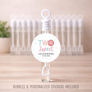 May include: Clear bubble wand with a white handle and a round sticker. The sticker reads "TWO Sweet" with a donut graphic and the text "Lily's 2nd Birthday 10.29.2026". Bubbles and personalized stickers included.